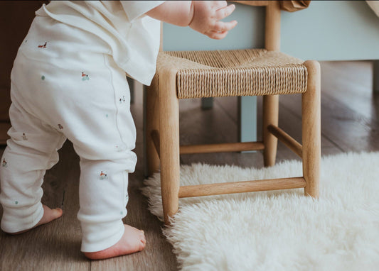 Light blue baby leggings with small patterns on a beige background