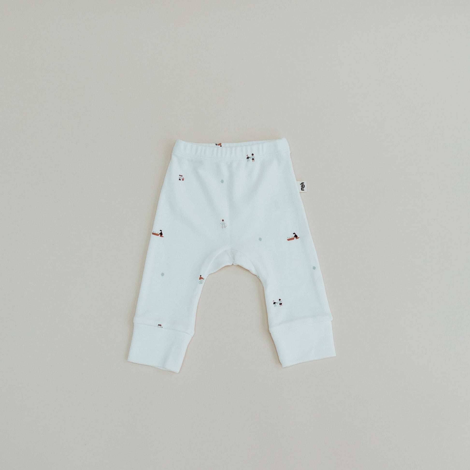 Light blue baby leggings with small patterns on a beige background