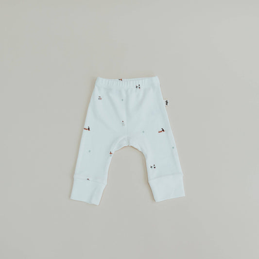 Light blue baby leggings with small patterns on a beige background