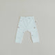 Light blue baby leggings with small patterns on a beige background