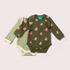 Green baby bodysuit with fox pattern and striped green and white onesie on a light gray background