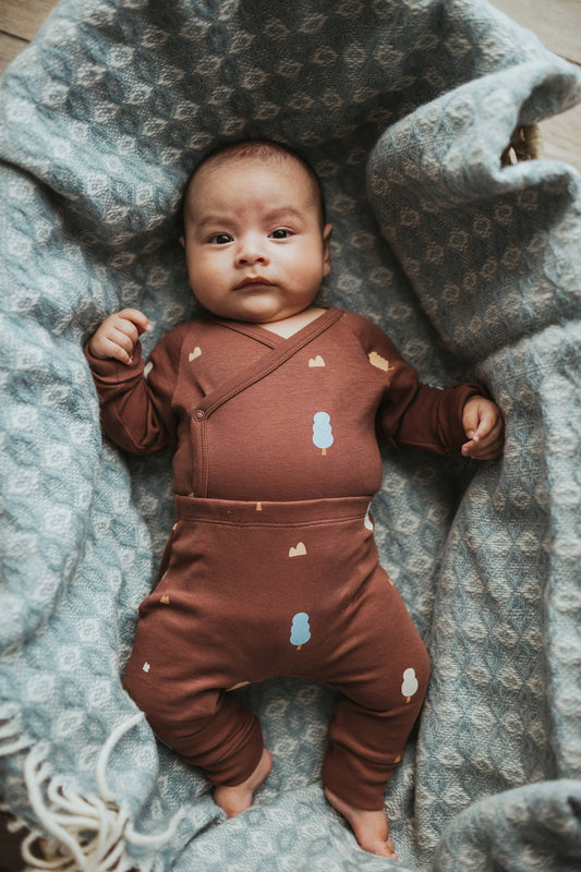 Brown baby pants with tree patterns on a beige background