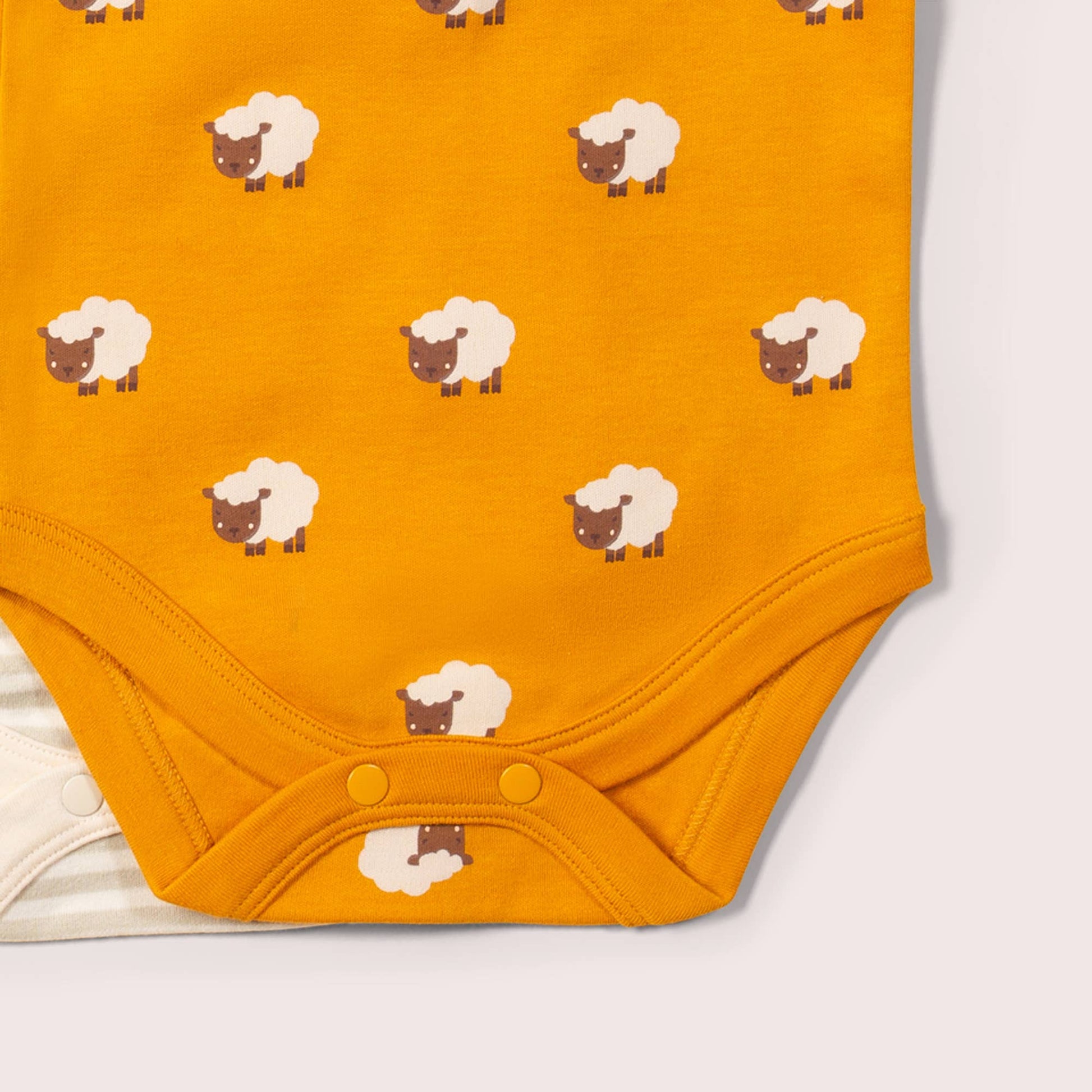 Yellow baby bodysuit with sheep pattern on a white background