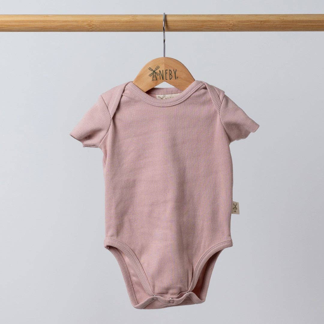 Pink baby bodysuit on a wooden hanger against a light gray background