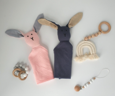 Four plush toys wrapped in colorful cloths on a white background