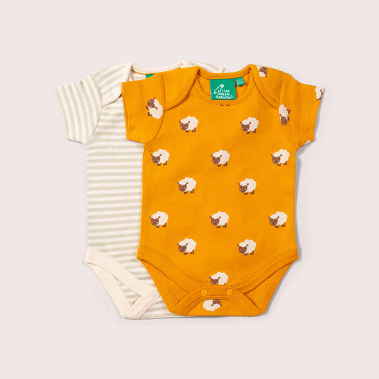 Yellow baby bodysuit with sheep pattern on a light gray background