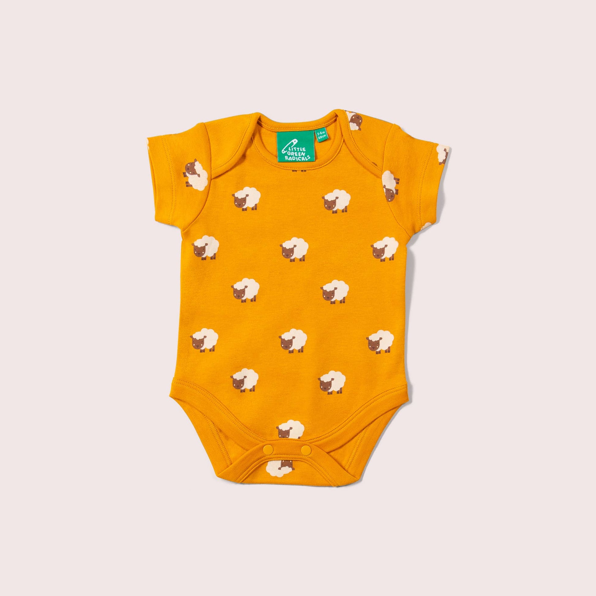 Yellow baby bodysuit with sheep pattern on a light gray background