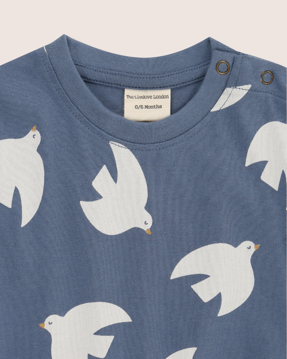 Blue baby's romper with white bird patterns on a plain background