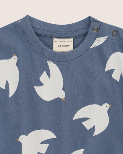 Blue baby's romper with white bird patterns on a plain background