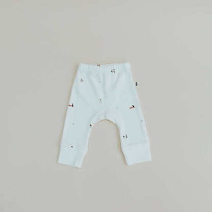 Light blue baby leggings with small patterns on a beige background