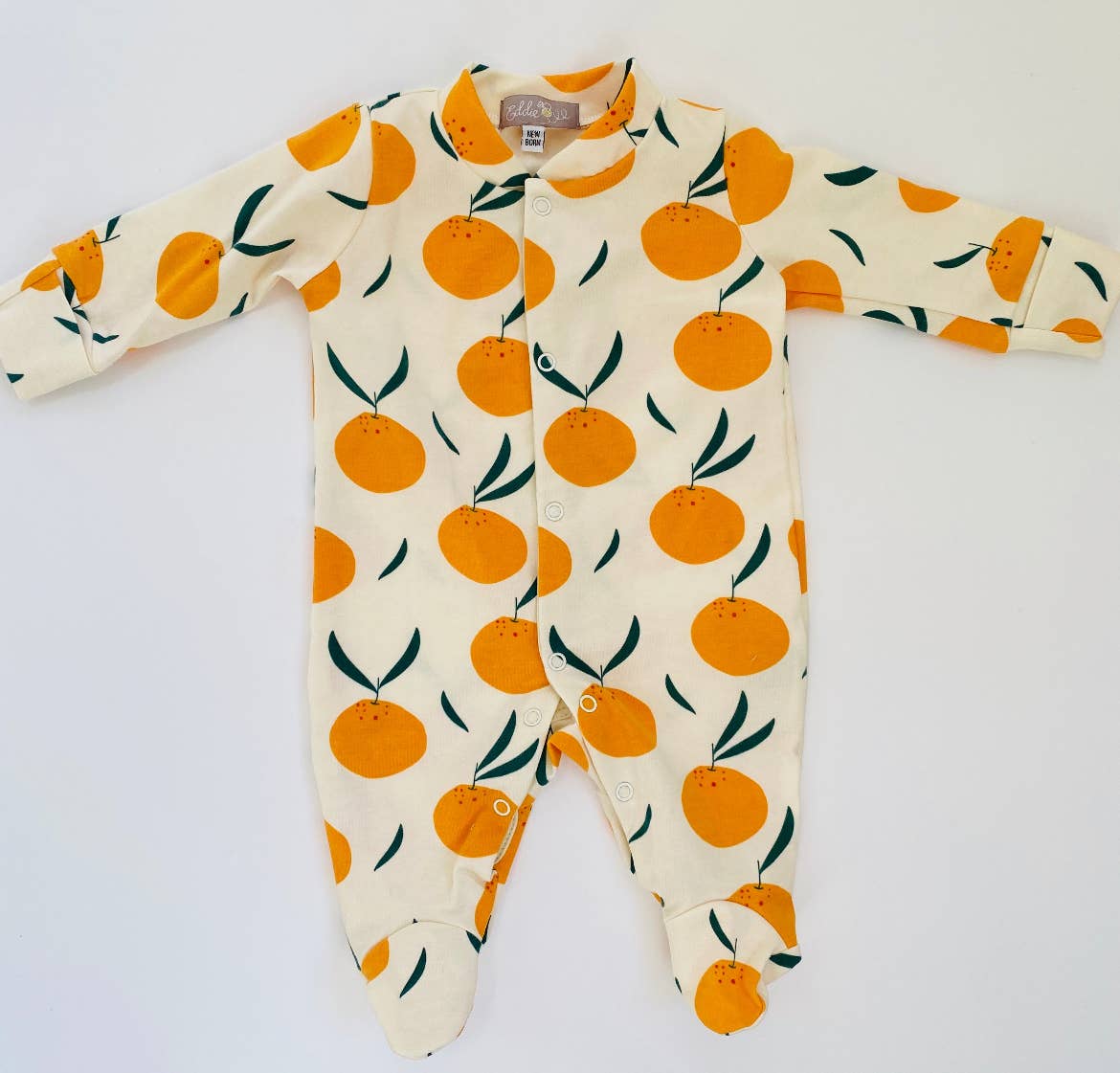 Baby sleepsuit with orange fruit pattern on a white background