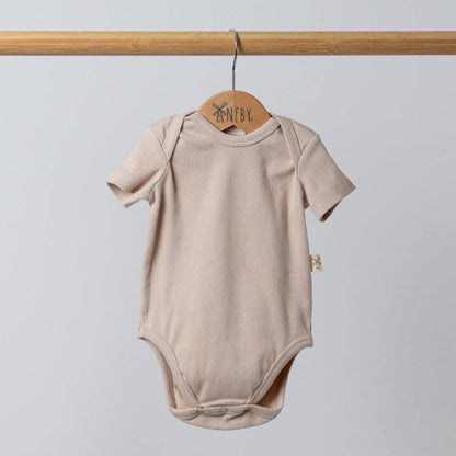 Beige baby bodysuit on a wooden hanger against a light gray background