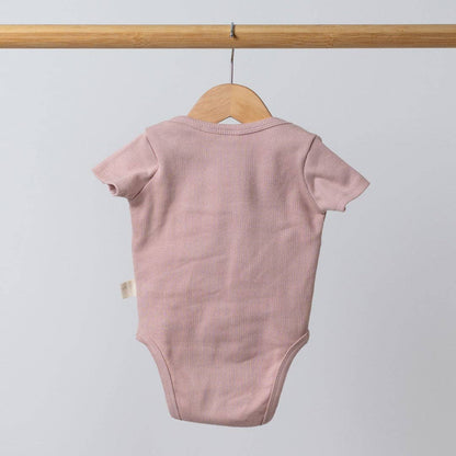 Pink baby bodysuit on a hanger against a light gray background