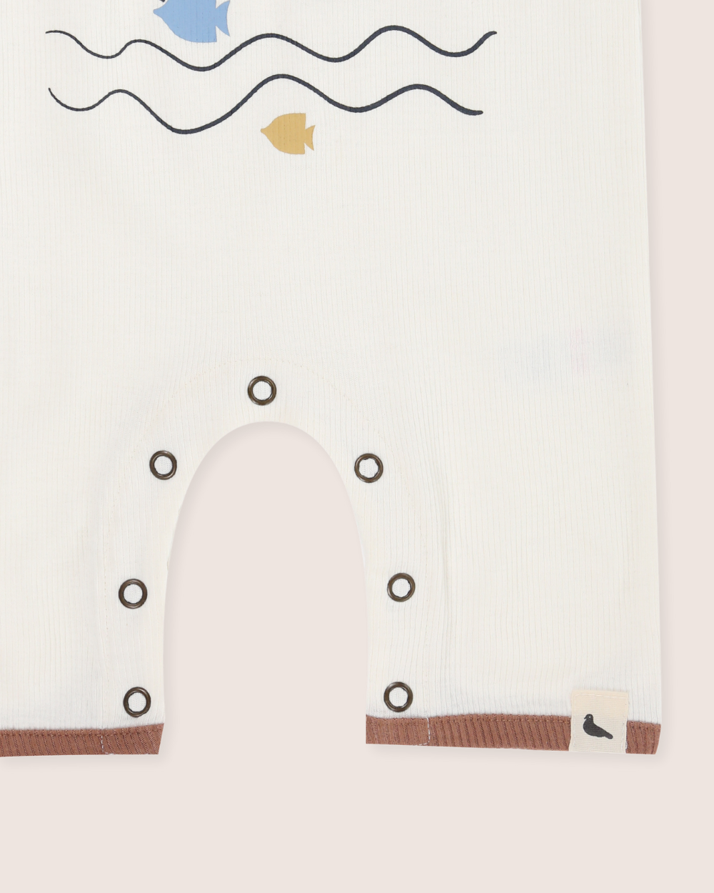 Baby's romper with whale design and minimalistic ocean elements on a white background
