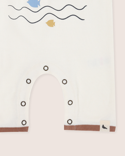 Baby's romper with whale design and minimalistic ocean elements on a white background