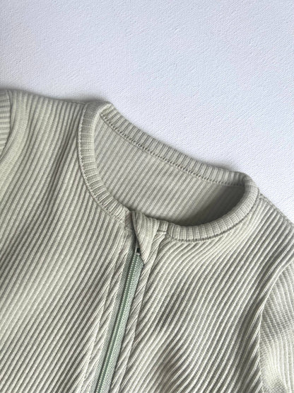 Close-up of a ribbed knit romper on a light gray background