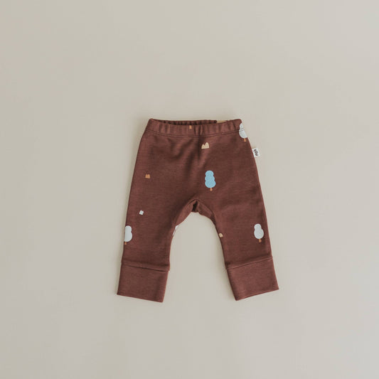 Brown baby pants with tree patterns on a beige background
