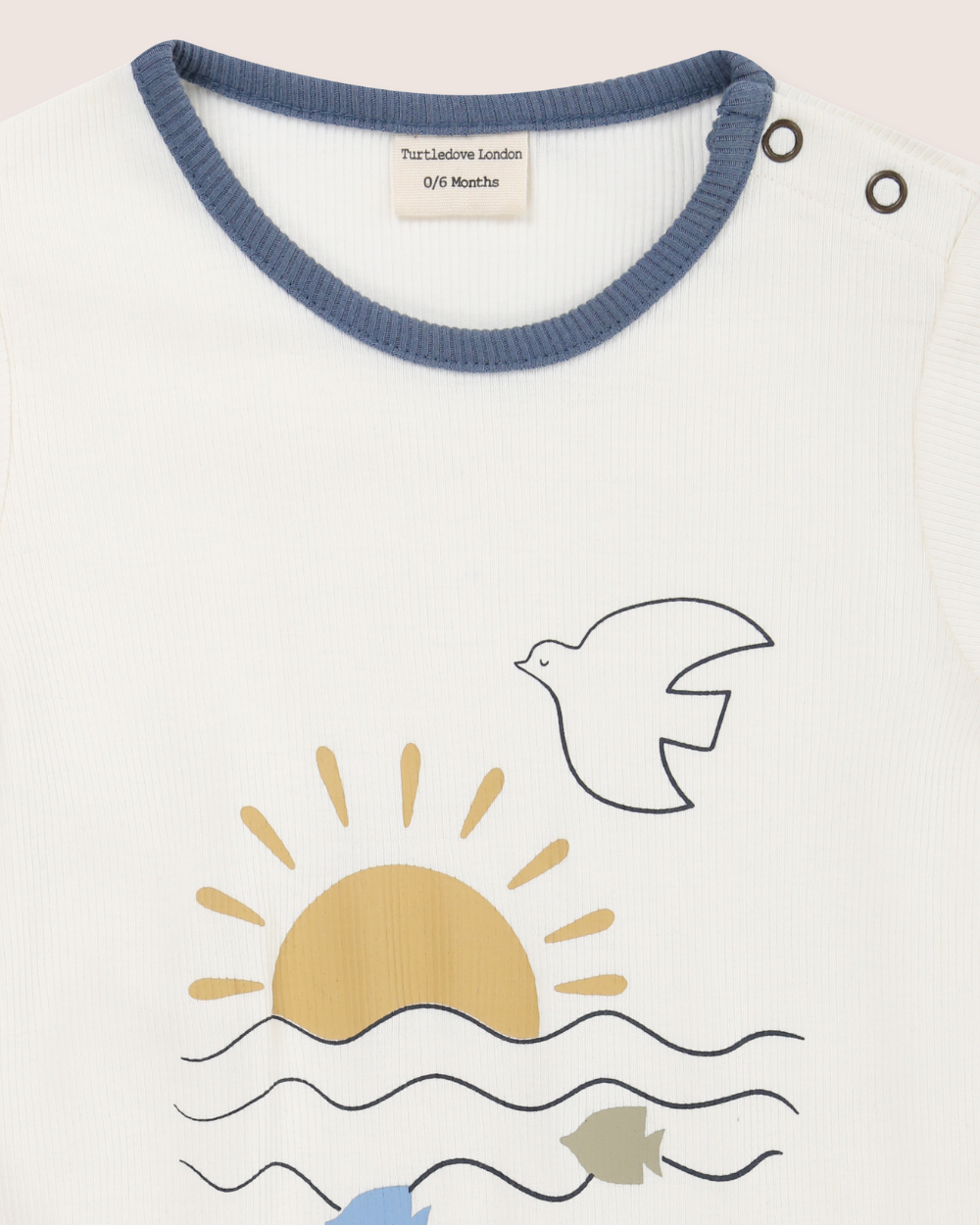 Baby romper with sun, dove, and fish design on a white background