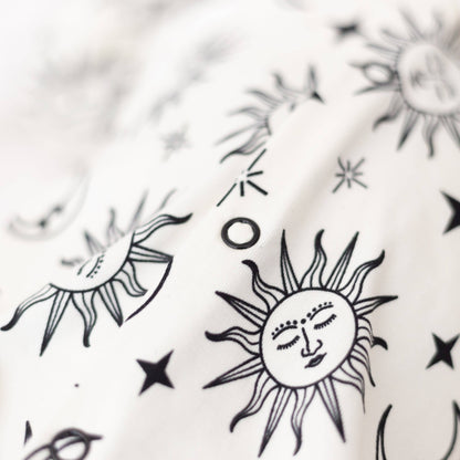 Black and white sun and star designs on a textured white background