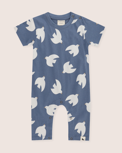 Blue baby romper with white bird pattern on a beige background