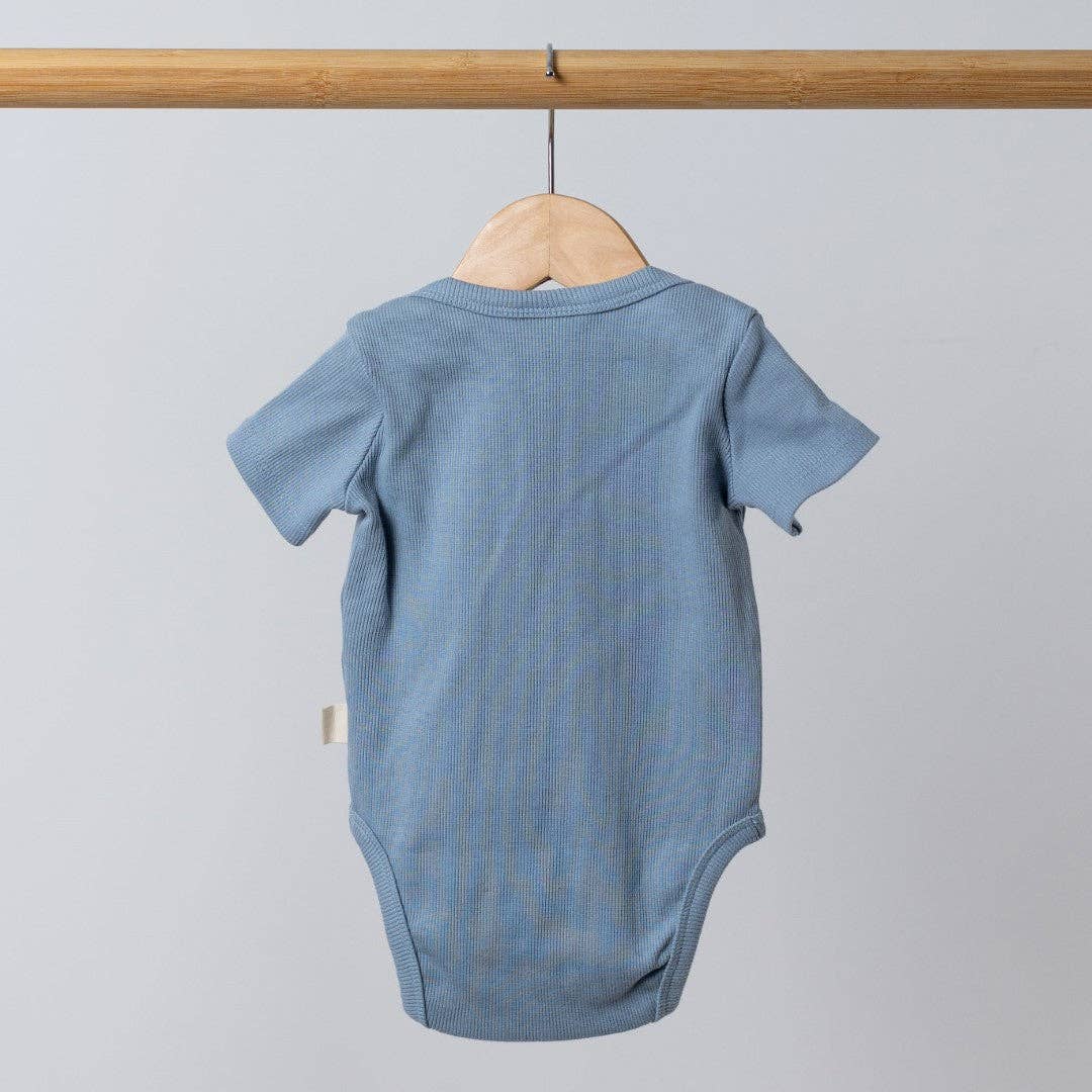 Blue baby bodysuit on a hanger against a light gray background
