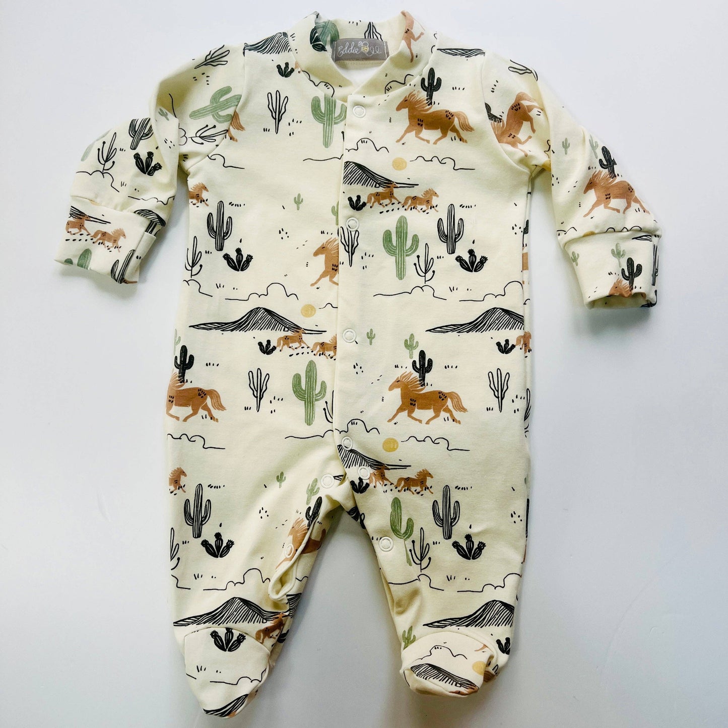 Baby sleepsuit with desert animal pattern on a light gray background