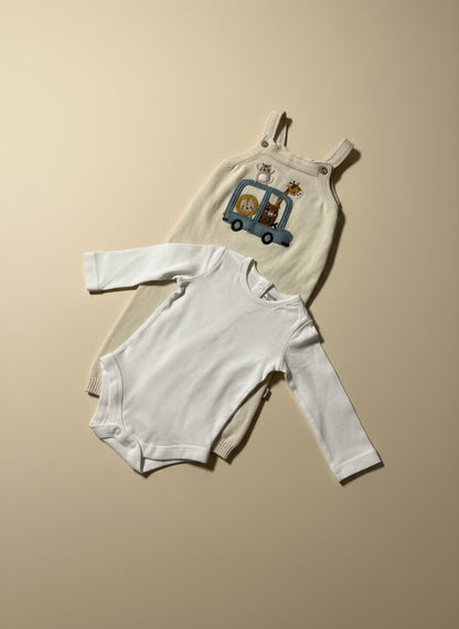 Baby dungaree with white bodysuit on a beige background