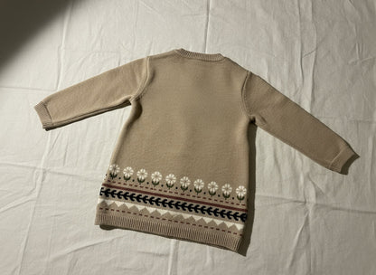 Beige sweater dress with floral pattern on a beige background